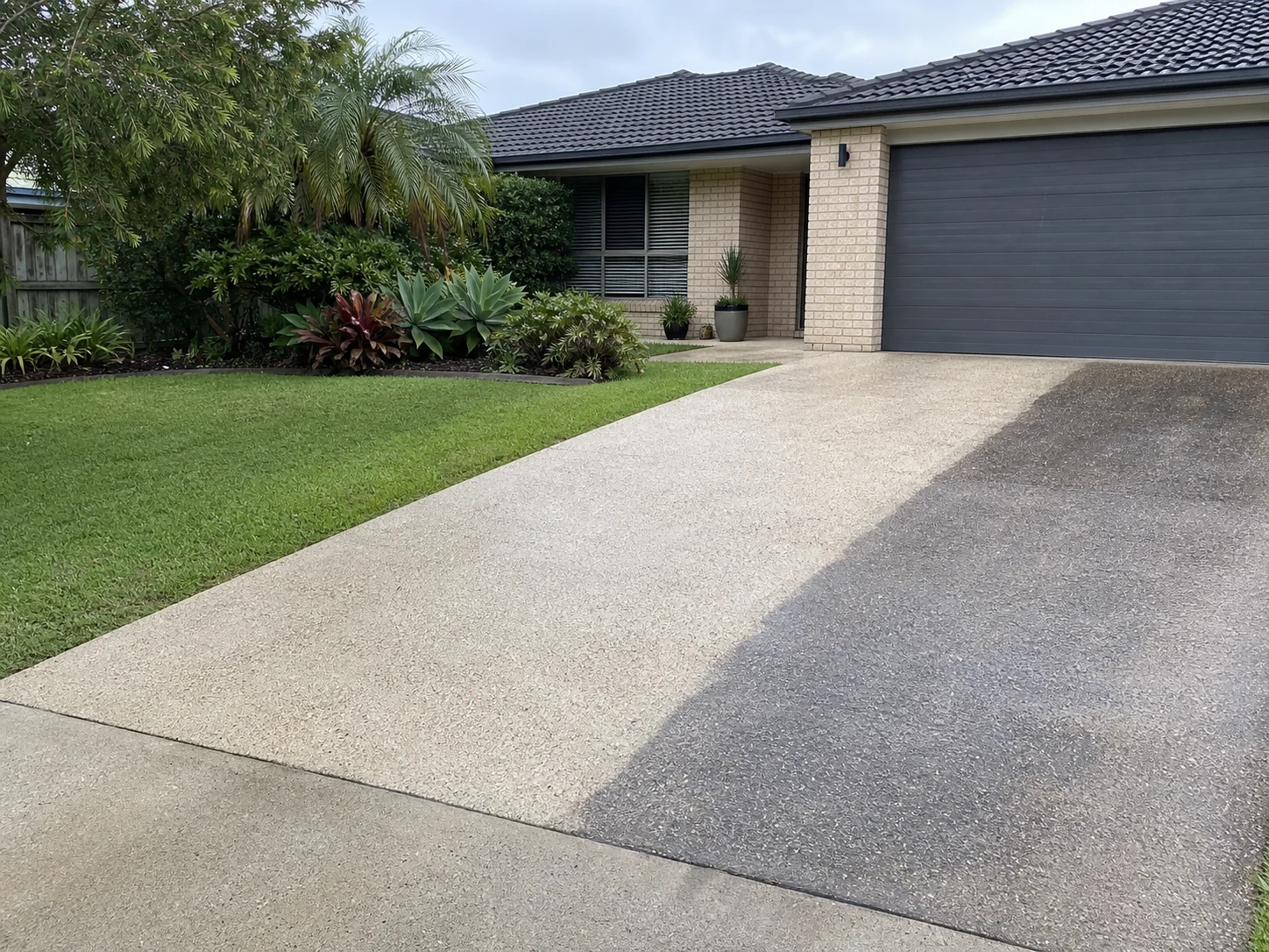 Concrete driveway showing the contrast between cleaned and weathered sections